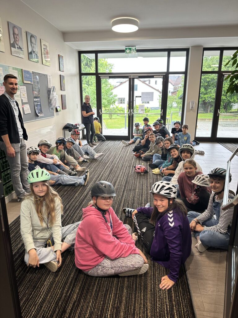 Schüler/innen ausgestattet mir ihren Helmen bekommen letzte Instruktionen für den Radparcours.